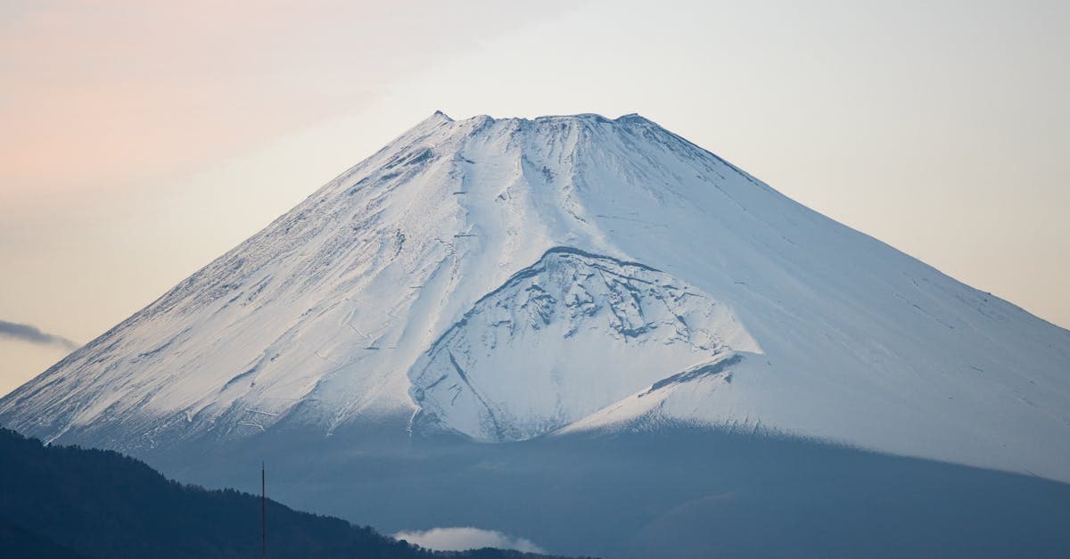 Serene view of Mount Fuji covered in snow under a calm sky, in Shizuoka, Japan.