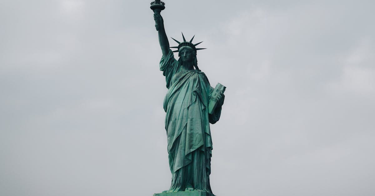 The Statue of Liberty stands tall against a cloudy sky in New York City, symbolizing freedom.