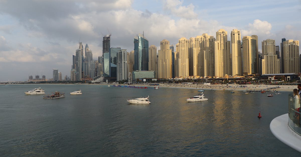 Breathtaking view of Dubai Marina's skyline with luxurious boats and clear waters during daytime.