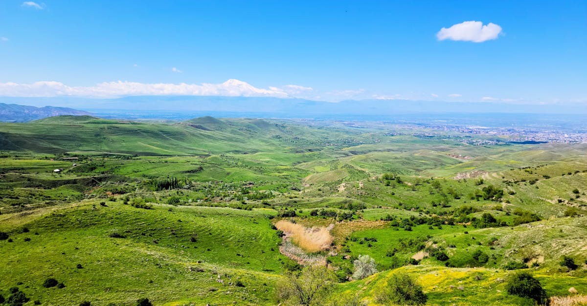 Explore the vibrant landscapes of Voghjaberd, Armenia with lush green hills and distant mountains.