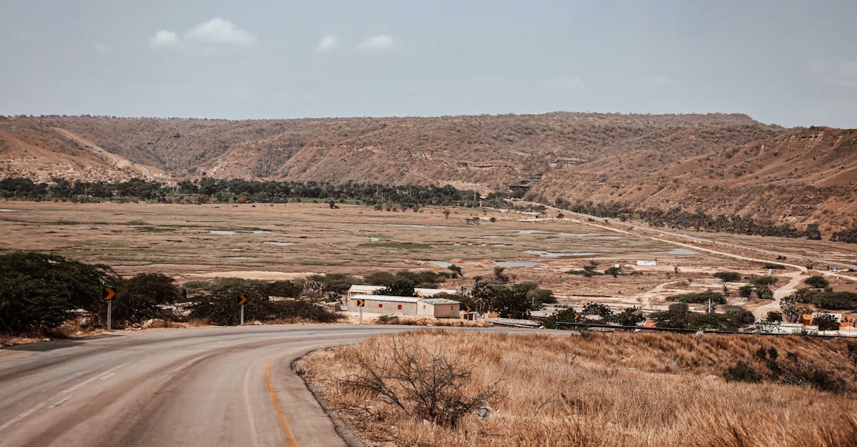 Explore the arid landscapes of Angola featuring winding roads and hill views.