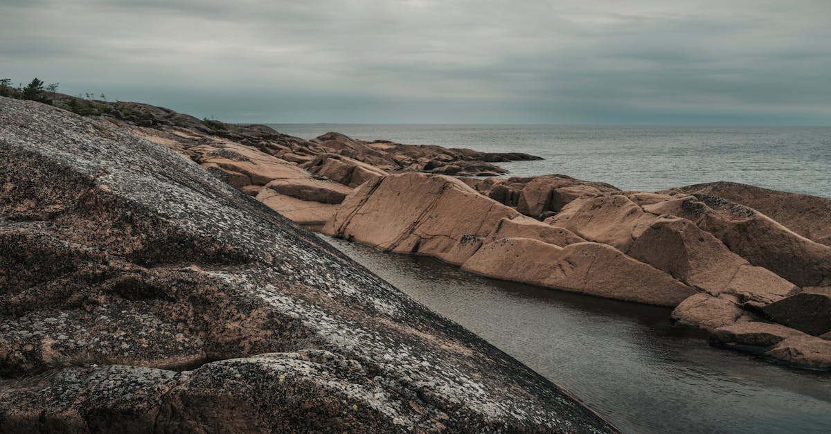 Moody view of rocky coastline and calm sea under an overcast sky on Åland Islands.