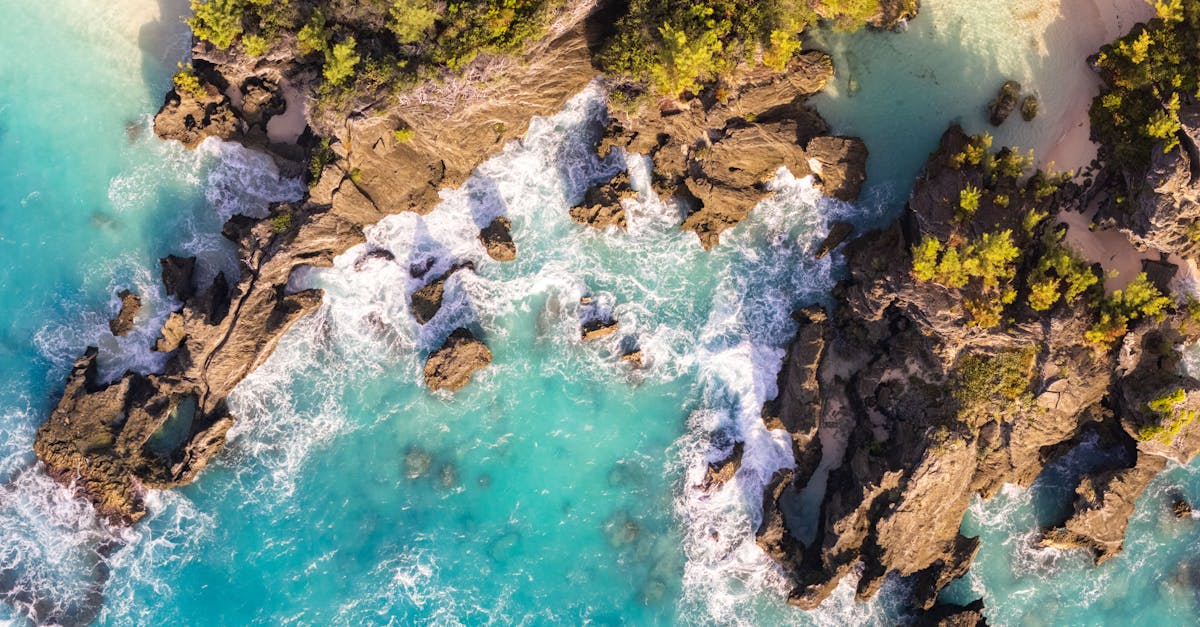 A stunning aerial view of Bermuda's rocky coastline with turquoise waters and waves crashing.