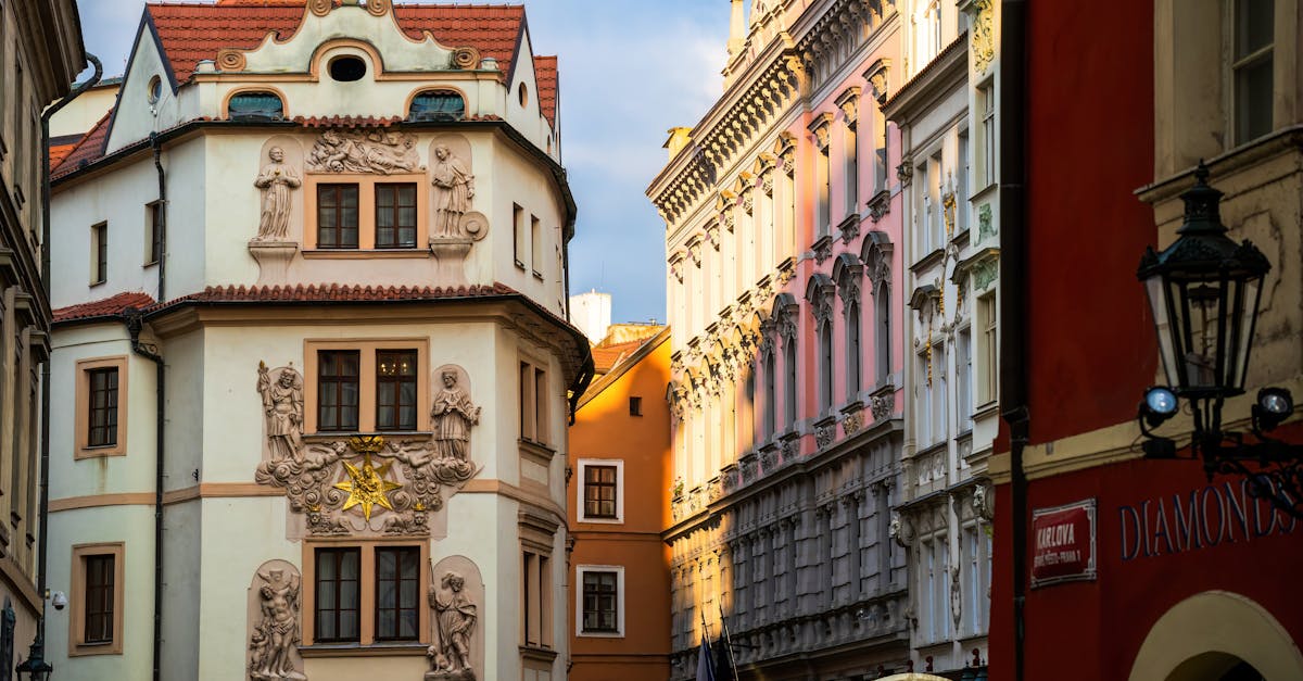 Charming street view of historic architecture in Prague city center, showcasing ornate facades in golden sunlight.