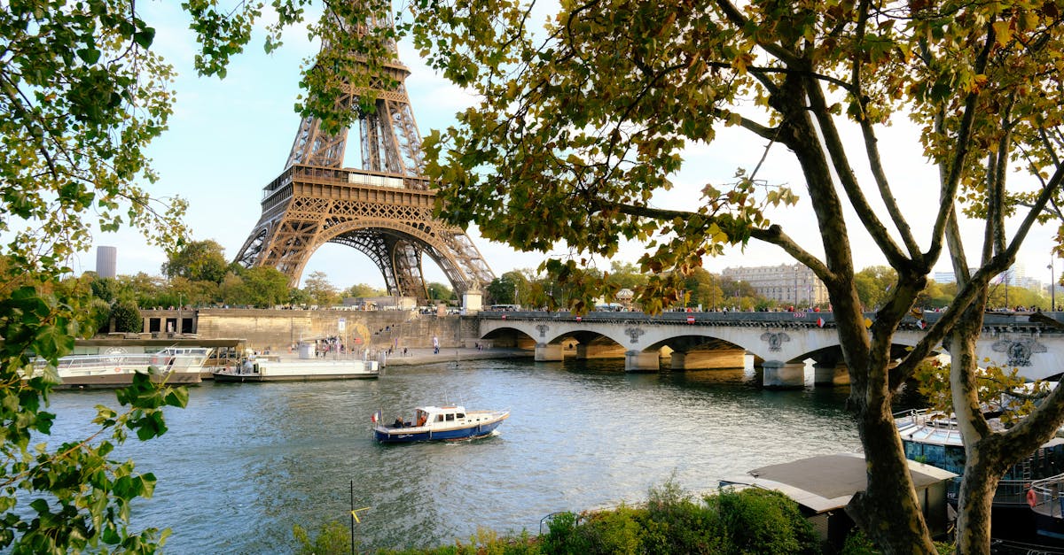 Captivating view of Eiffel Tower over Seine River with lush trees in Paris, France.