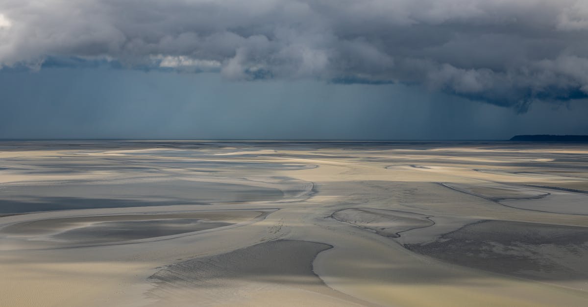 Moody clouds cast shadows over the sweeping sands of Normandy's coastal landscape.