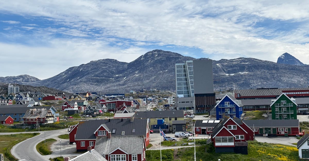 A picturesque view of Nuuk with colorful buildings against a mountainous backdrop.