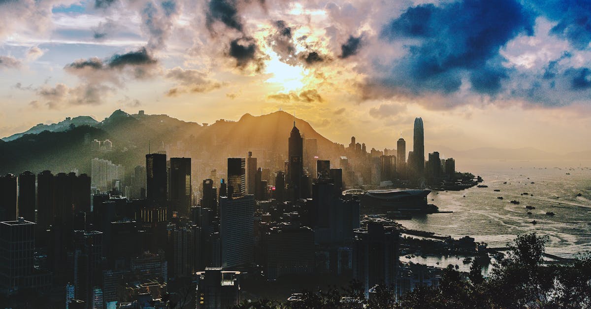 Dramatic sunset over the skyline of Hong Kong Island with vibrant colors and sea view.