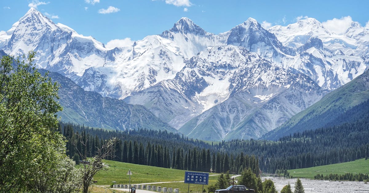 Breathtaking view of the snow-capped Tian Shan Mountains under a bright blue sky, perfect for nature and travel imagery.