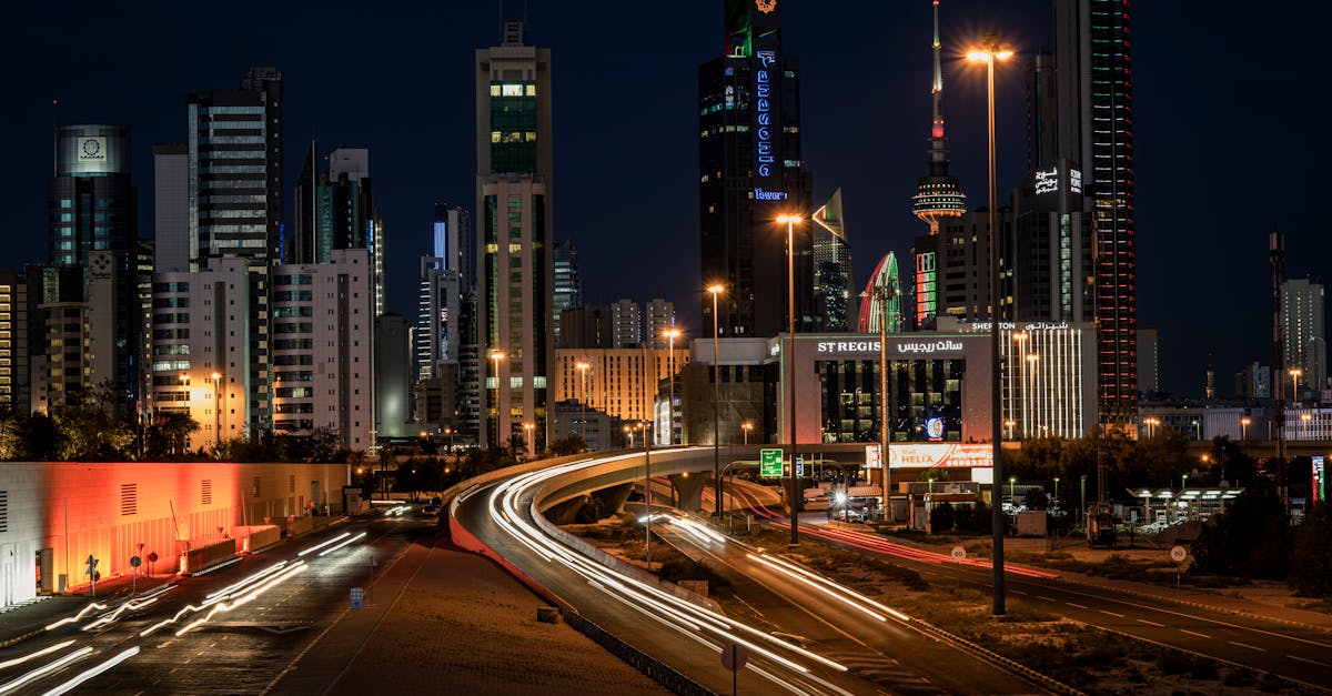 Vibrant night view of Kuwait City's skyline showcasing modern architecture and light trails.