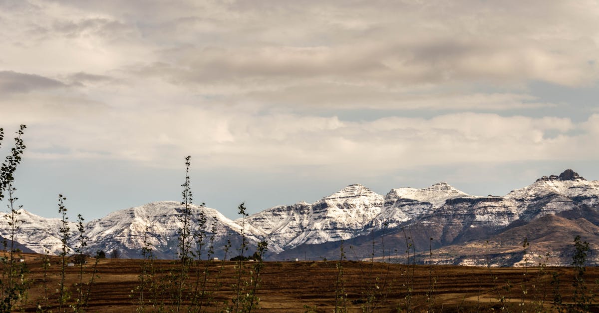 Serene view of snow-capped mountains under a cloudy sky in Teyateyaneng, Lesotho.