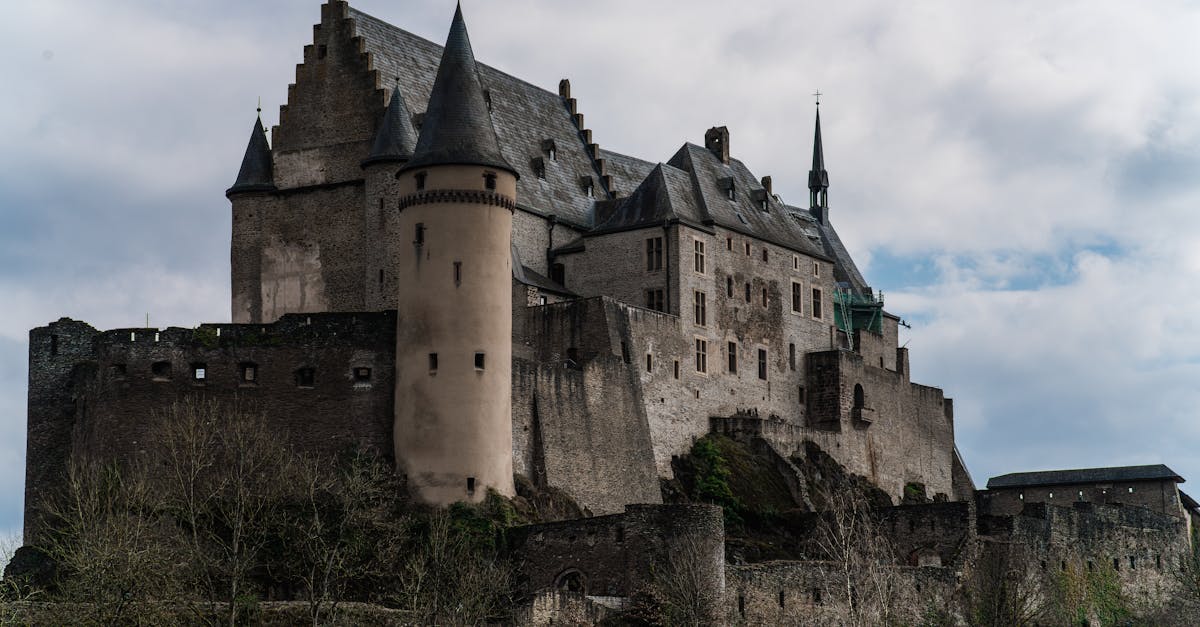 Historic Vianden Castle in Luxembourg captures medieval architecture against a cloudy sky.