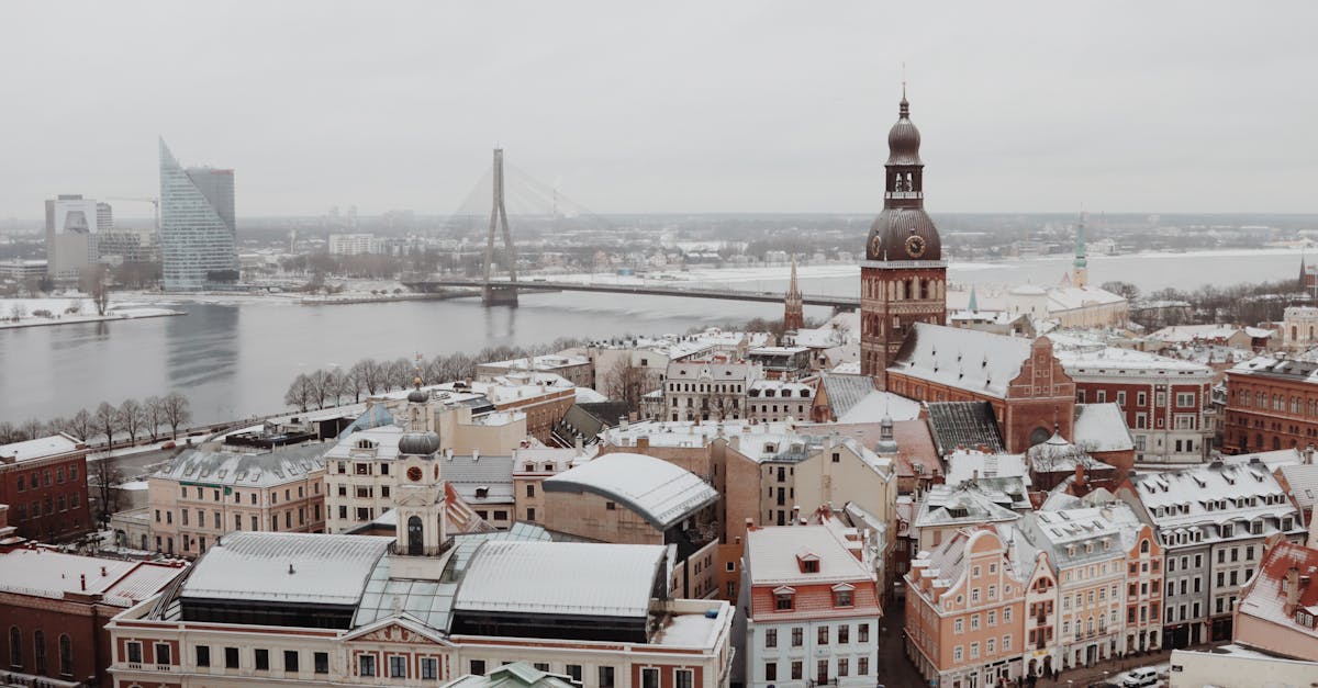 Aerial shot of snow-covered Old Town Riga with the Daugava River and iconic architecture in winter.