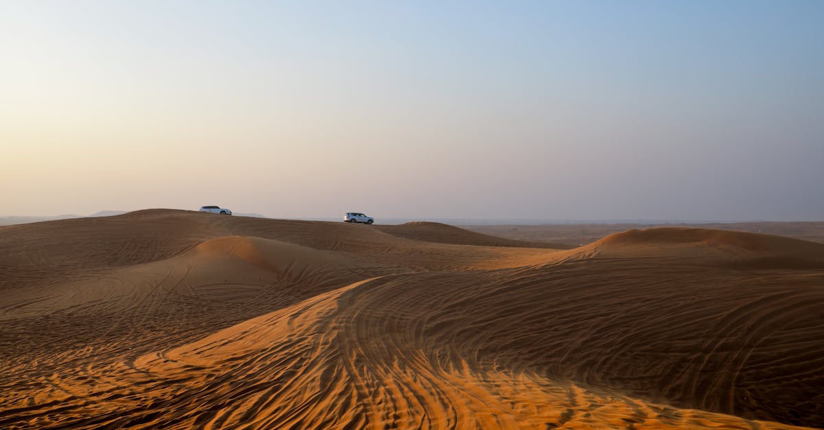 Traversing the serene desert dunes by car, capturing the essence of a desert safari at dawn.