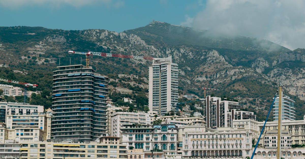 A captivating skyline of Monaco with modern architecture against lush hills under a summer sky.
