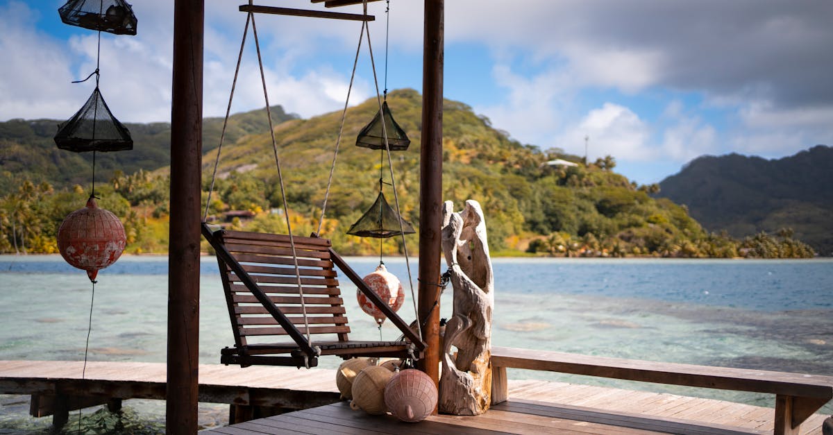 Cozy swing on a porch with stunning view of Huahine's tranquil waters and lush mountains.