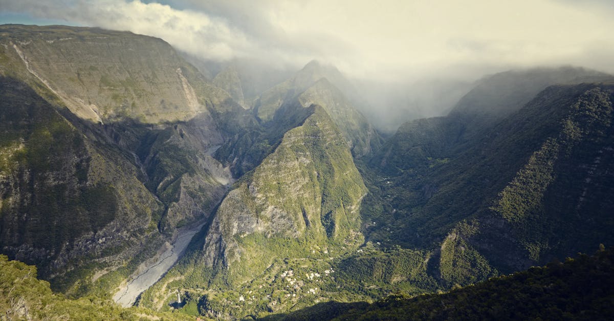 Breathtaking aerial view of lush green mountain valleys shrouded in clouds.