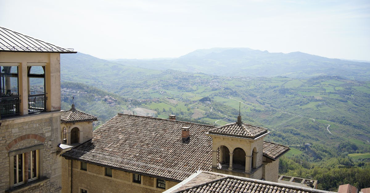 Panoramic view of rooftops and lush green hills in Città di San Marino.