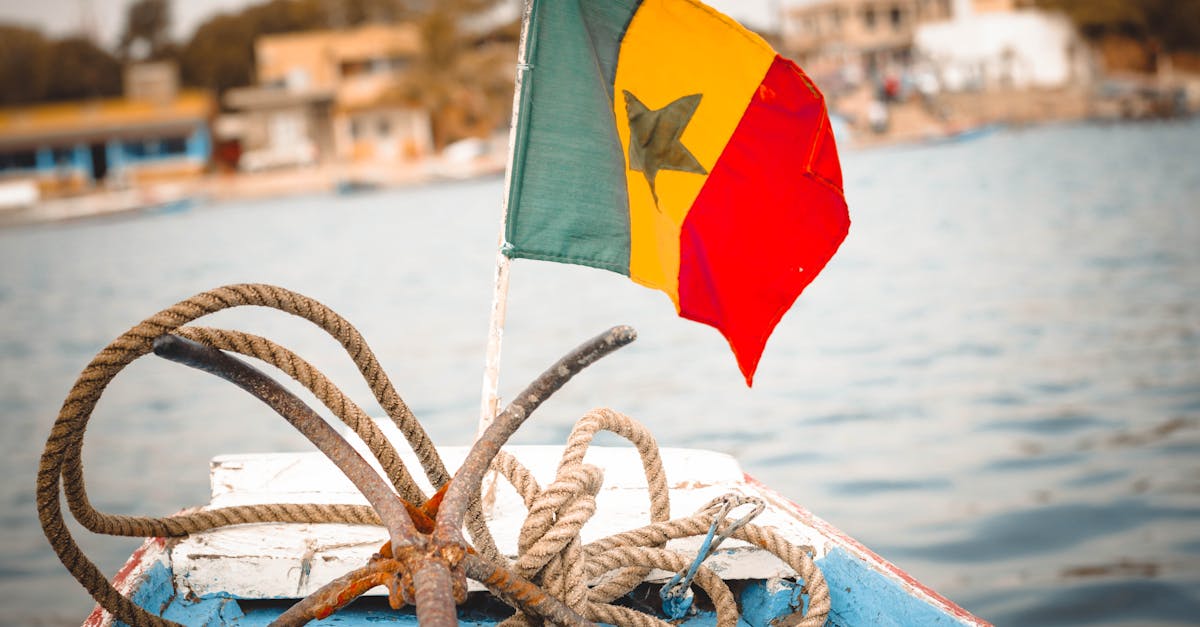 Colorful Senegalese flag and nautical ropes on a boat deck, perfect for travel themes.