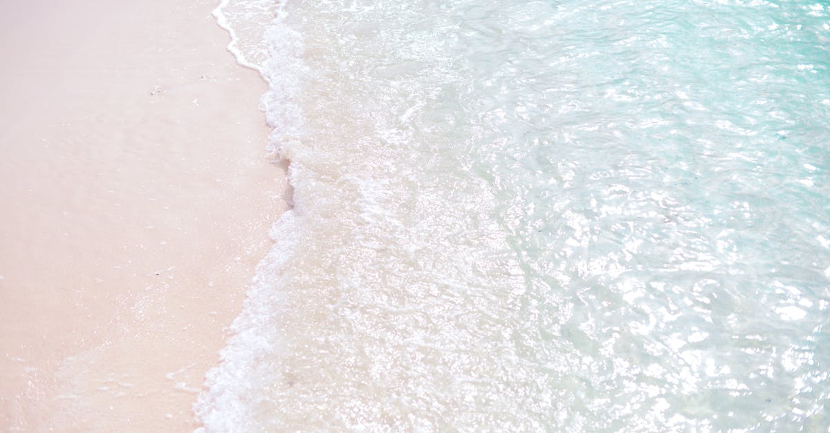 Tranquil scene of waves on a white sand beach, clear turquoise waters.