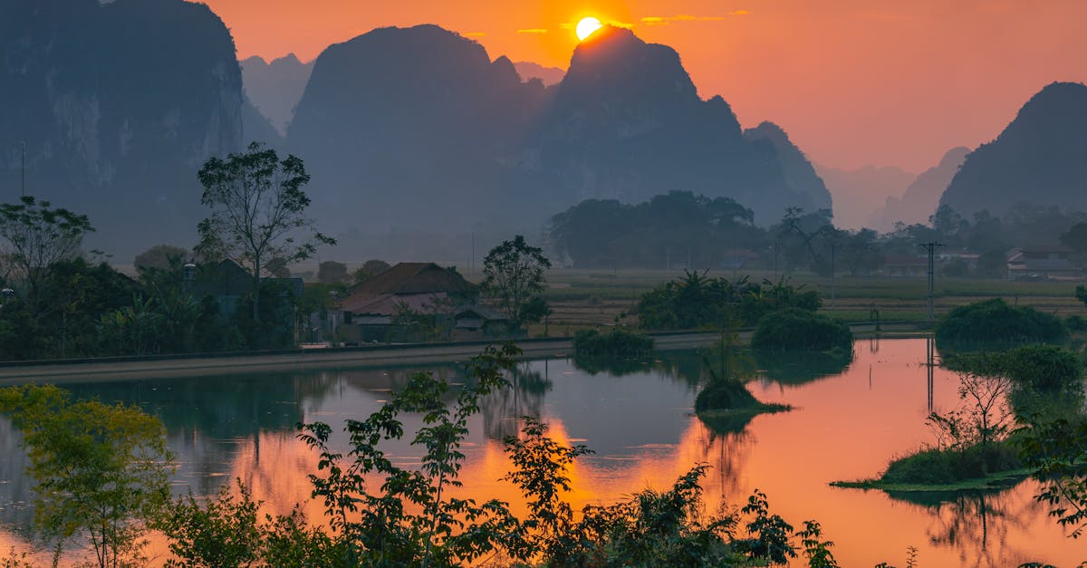 Serene sunset view over Lạng Sơn's majestic mountains reflecting in a tranquil lake.