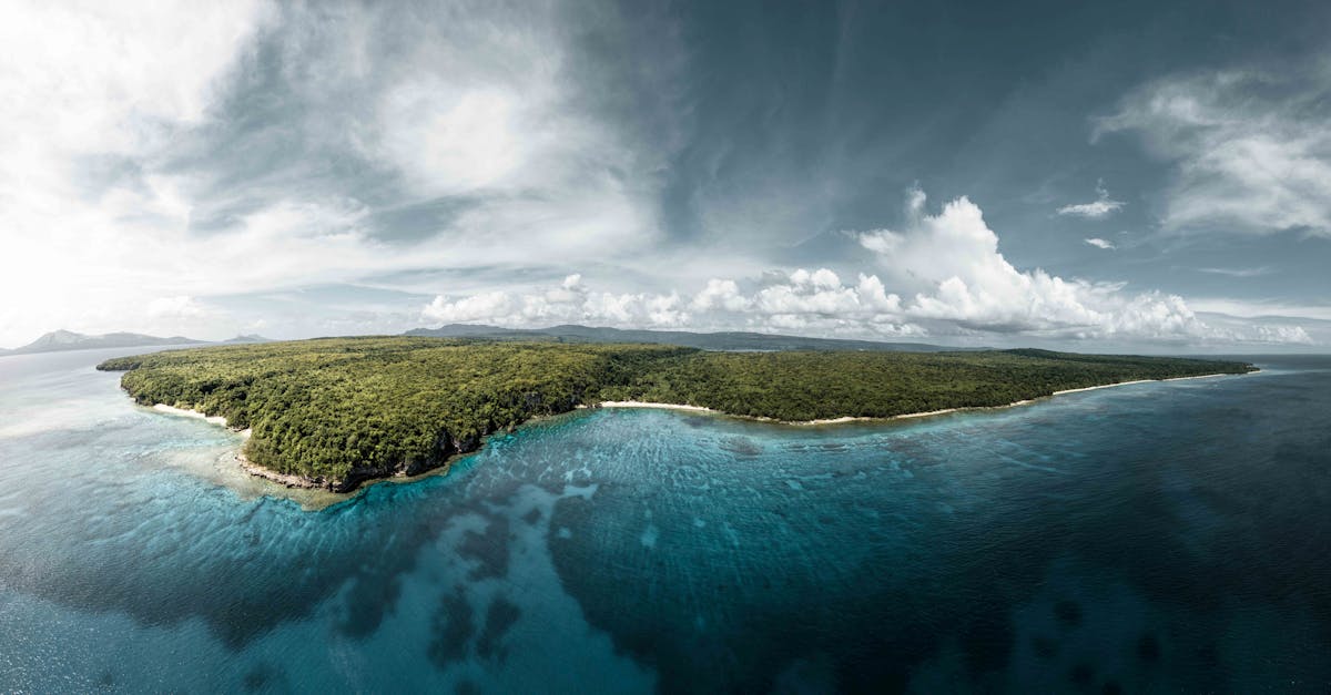 A breathtaking aerial view of the lush green coastline of Vanuatu, surrounded by crystal clear waters.